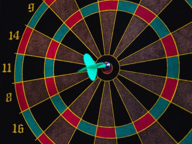 A dart striking the bullseye of a dartboard, representing the precision and clarity achieved when contemplating the decision to share or withhold personal goals and motivations