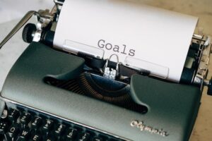 A vintage Olympia typewriter showcasing the word 'Goals', illustrating the contemplation of documenting and sharing personal aspirations and motivations.