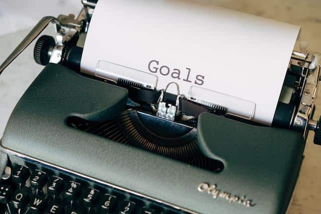 A vintage Olympia typewriter showcasing the word 'Goals', illustrating the contemplation of documenting and sharing personal aspirations and motivations.